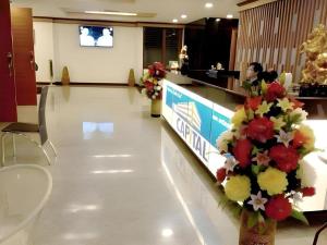a lobby with a counter with flowers on it at The Capital Hotel in Roi Et