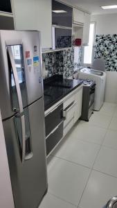 a kitchen with a stainless steel refrigerator and appliances at Luxus Duplex 102m2 Vista Mar - Vilas do Atlântico in Lauro de Freitas