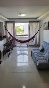 a living room with a couch and a hammock in it at Luxus Duplex 102m2 Vista Mar - Vilas do Atlântico in Lauro de Freitas