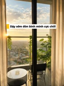 a room with a large window with a table and chairs at HERE Stay in An Khê
