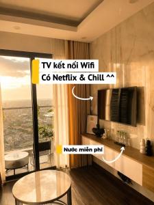 a living room with a tv and a table in a room at HERE Stay in An Khê +7 photos