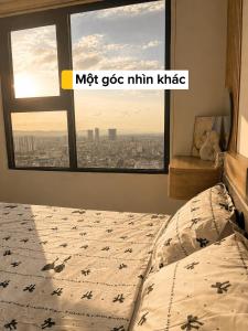 a bed in a bedroom with a view of a city at HERE Stay in An Khê