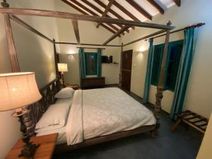 a bedroom with a canopy bed with a table and a lamp at Sagala Boutique Hotel in Bandarawela