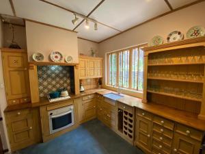 a large kitchen with wooden cabinets and a window at Sagala Boutique Hotel in Bandarawela