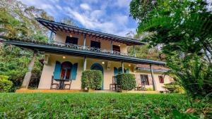 a yellow house with blue doors and a yard at Sagala Boutique Hotel in Bandarawela