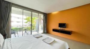 a bedroom with a white bed and a large window at The Living Pool Villas in Ban Ko Khwan
