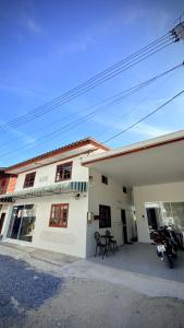 a white building with a table in front of it at Traditional Thai House Chaloklum in Chaloklum