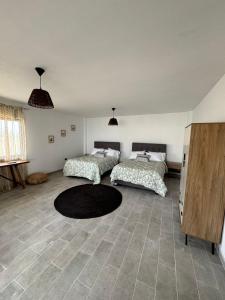 a bedroom with two beds and a rug on the floor at LA SIESTA Suites in Huarmey