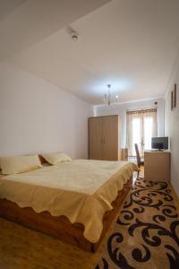 a bedroom with a large bed and a chair at Hotel Foisor in Bucharest
