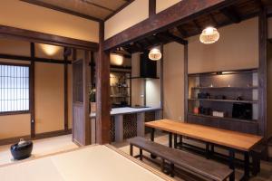 a dining room with a wooden table and benches at Temple Stay KAN 観 in Yokosuka