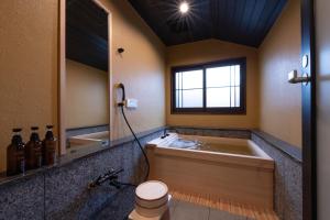 a bathroom with a tub and a toilet and a mirror at Temple Stay KAN 観 in Yokosuka +23 photos