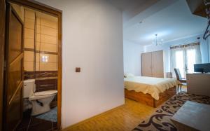1 dormitorio con 1 cama y aseo en una habitación en Hotel Foisor en Bucarest