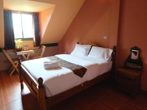 a bedroom with a bed and a table and a window at Tai Asean House in Ban Kham Kling +135 photos
