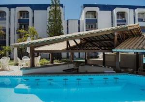 a large swimming pool with a large building in the background at Luxus Duplex 102m2 Vista Mar - Vilas do Atlântico in Lauro de Freitas