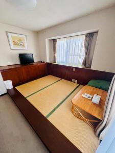 a bedroom with a large bed and a table at Pension Green Grass in Kamakura