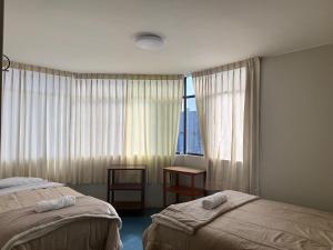 a hotel room with two beds and a window at Oasis in Tacna