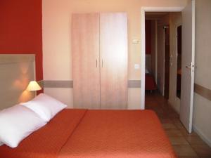 a bedroom with a bed and a cabinet and a hallway at Hôtel La Flore in Villefranche-sur-Mer