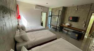 a hotel room with two beds and a desk at palmhouse in Mae Hong Son