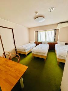 a hospital room with two beds and a table at Pension Green Grass in Kamakura +23 photos