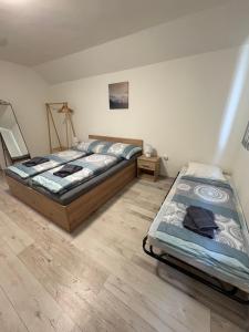 two twin beds in a room with wooden floors at Villa Palma Balatonboglár in Balatonboglár +24 photos
