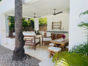 a living room with a table and a tree at Nyumba Nyekundu in Watamu