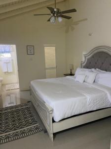 a bedroom with a white bed with a ceiling fan at Winslow Place in Falmouth +65 photos