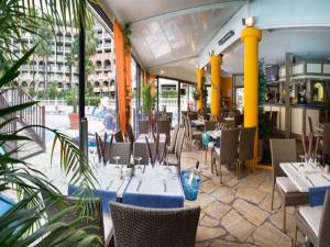 un ristorante con tavoli e sedie blu e un edificio di Cannes Front Beach Pools Apartment a Cannes