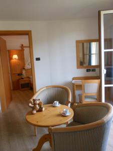 a room with a table and chairs and a kitchen at Il Falchetto in Sarnonico
