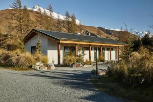 a house on a road next to a mountain at Glentanner Park Centre in Glentanner