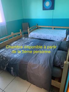 a bedroom with a bed and a clock on the wall at Les Hibiscus in Saint-Philippe