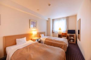 a hotel room with two beds and a television at Hirosaki Plaza Hotel in Hirosaki +34 photos