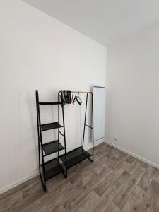 a black ladder in a room with a white wall at Chambre avec salle de bain privé in Neuvic