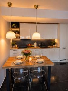 a kitchen with a wooden table with plates and candles at Apartament Słowik Lux in Rowy