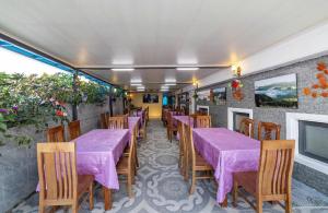 a dining room with purple tables and wooden chairs at Maro Luxury Boutique Villa - hotel in Da Thanh