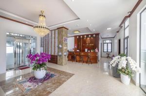 a lobby with flowers in white vases on the floor at Maro Luxury Boutique Villa - hotel in Da Thanh