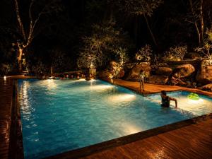 a man in a swimming pool at night at Mount Rich Rumassala By JMS Group in Unawatuna
