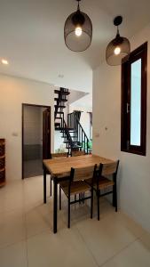 a dining room with a wooden table and chairs at Happy House in Chaloklum in Chaloklum