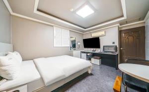 a bedroom with a bed and a desk and a television at Dapsimni Hotel Grim in Seoul