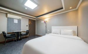 a hotel room with a bed and a table and chairs at Dapsimni Hotel Grim in Seoul