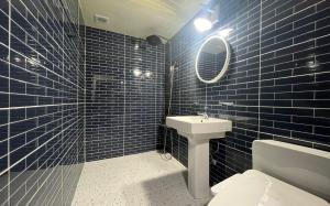 a blue tiled bathroom with a toilet and a sink at Dapsimni Hotel Grim in Seoul