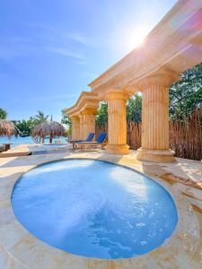 a swimming pool in a backyard with a wooden pergola at Tritonia Island Tintipán in Tolú