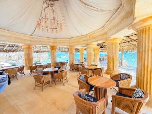 a restaurant with tables and chairs and a chandelier at Tritonia Island Tintipán in Tolú