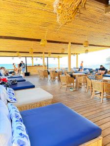 a deck with blue tables and chairs on the beach at Tritonia Island Tintipán in Tolú