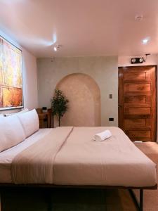 a bedroom with a large bed and a wooden door at Island Pod in El Nido