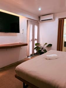 a bedroom with a bed and a tv and a window at Island Pod in El Nido +27 photos