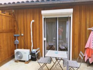 a patio with a heater and a table and chairs at perigordchambre in Sarlat-la-Canéda