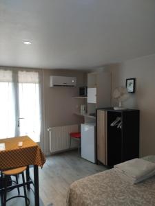 a room with a bed and a table and a kitchen at perigordchambre in Sarlat-la-Canéda