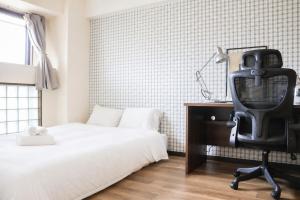 a bedroom with a bed and a desk and a chair at サンヒルズマンション in Tosu