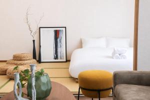 a bedroom with a bed and a table and a chair at サンヒルズマンション in Tosu