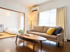 a living room with a couch and a coffee table at サンヒルズマンション in Tosu